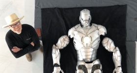亚当·萨维奇站在组装好的3D打印铁人套装旁边。照片来源：亚当·萨维奇