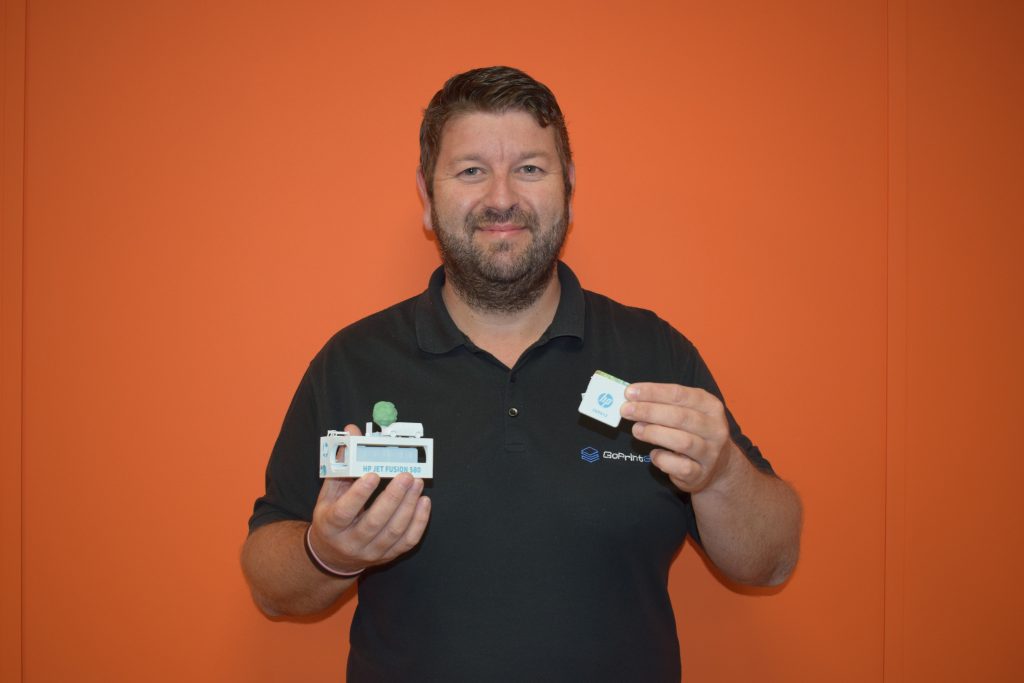 James Blackburn, Sales Director at GoPrint3D, holds two full color 3D prints from the HP Jet Fusion 300/500 series. Photo via HP