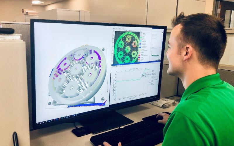 Researcher Chase Joslin using the Peregrine software to monitor and analyze a component being 3D printed. at ORNL. Photo via Luke Scime/ORNL.
