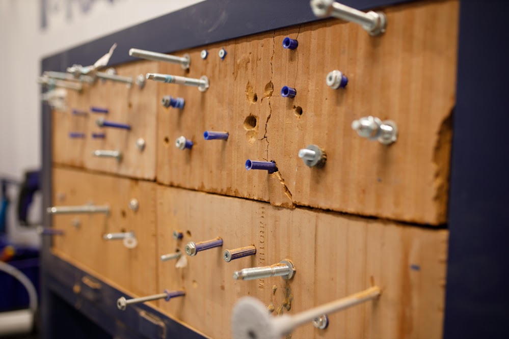 A cork board with several different mountings and fixtures attached.