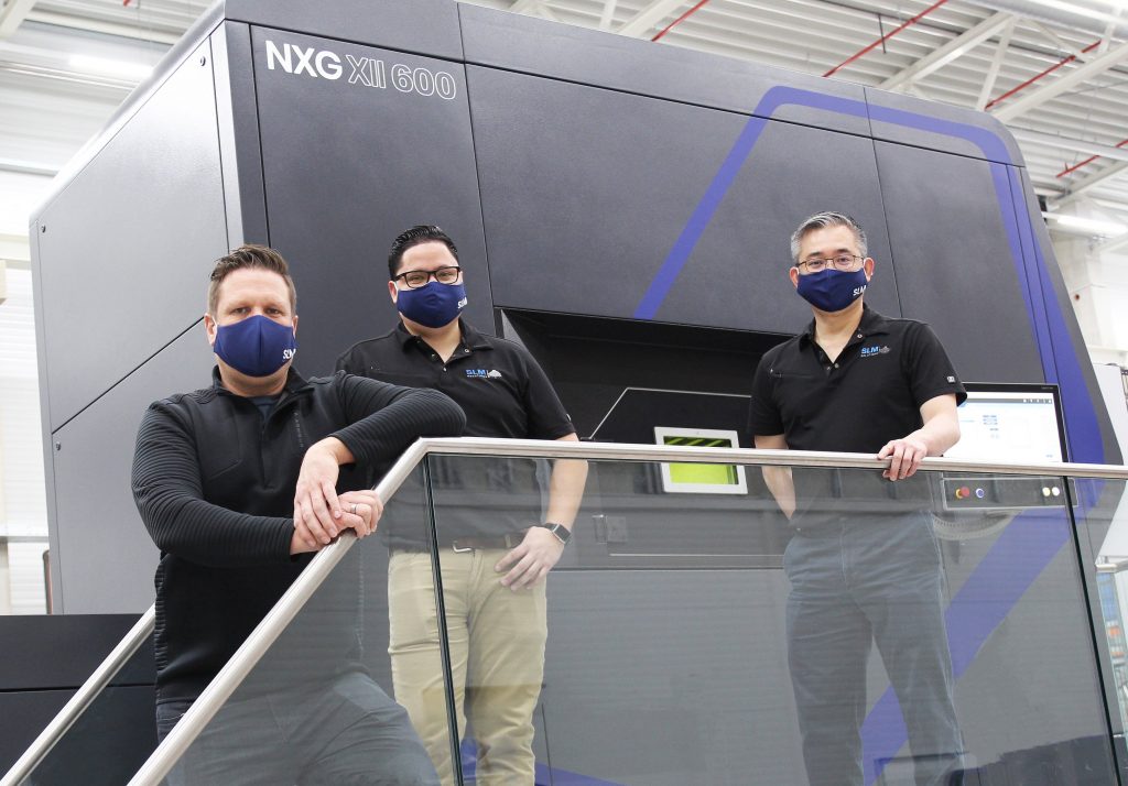 SLM解决方案团队成员正在接受新NXG XII 600 3D打印机的培训。