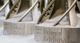 Prima Additive's logo 3D printed into some metal parts.