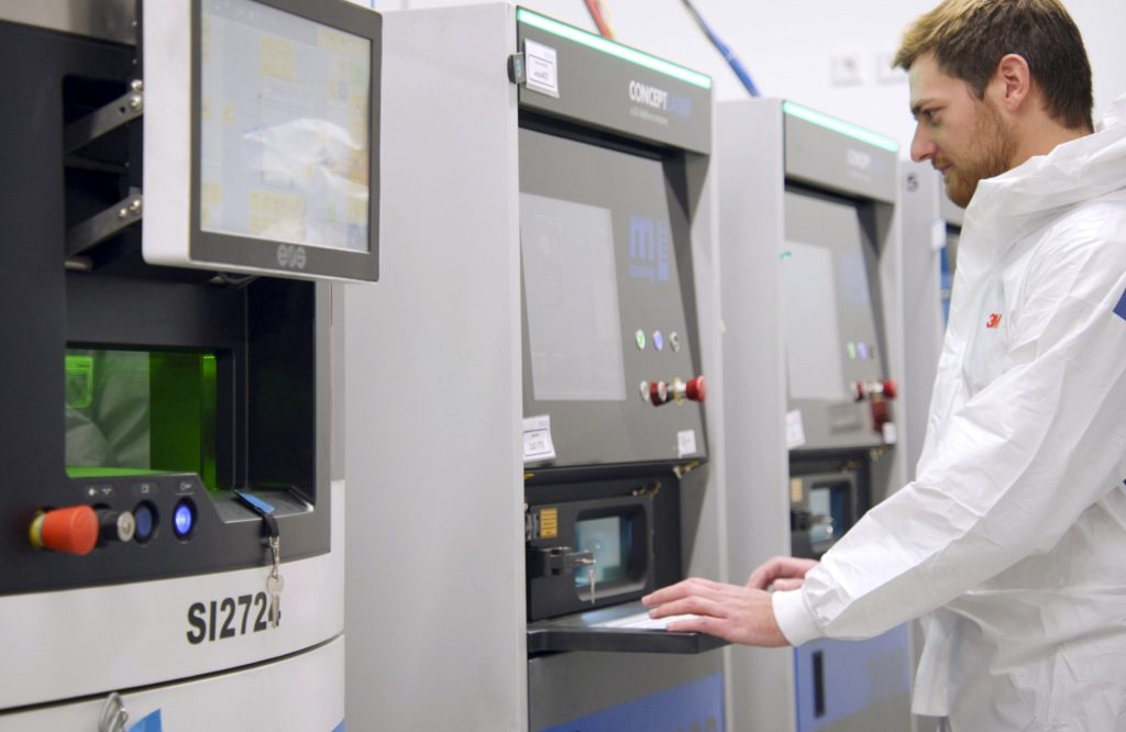一名Protolabs工程师正在操作新工厂60台3D打印机中的一台。