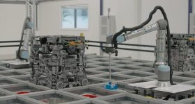 3D打印的600系列机器人与机器人臂结合使用，将杂货订单放在货车中。通过Ocado的照片。
